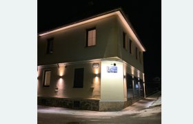 Nachts beleuchtetes Geb&auml;ude mit der Aufschrift 'Haus Zwei'.