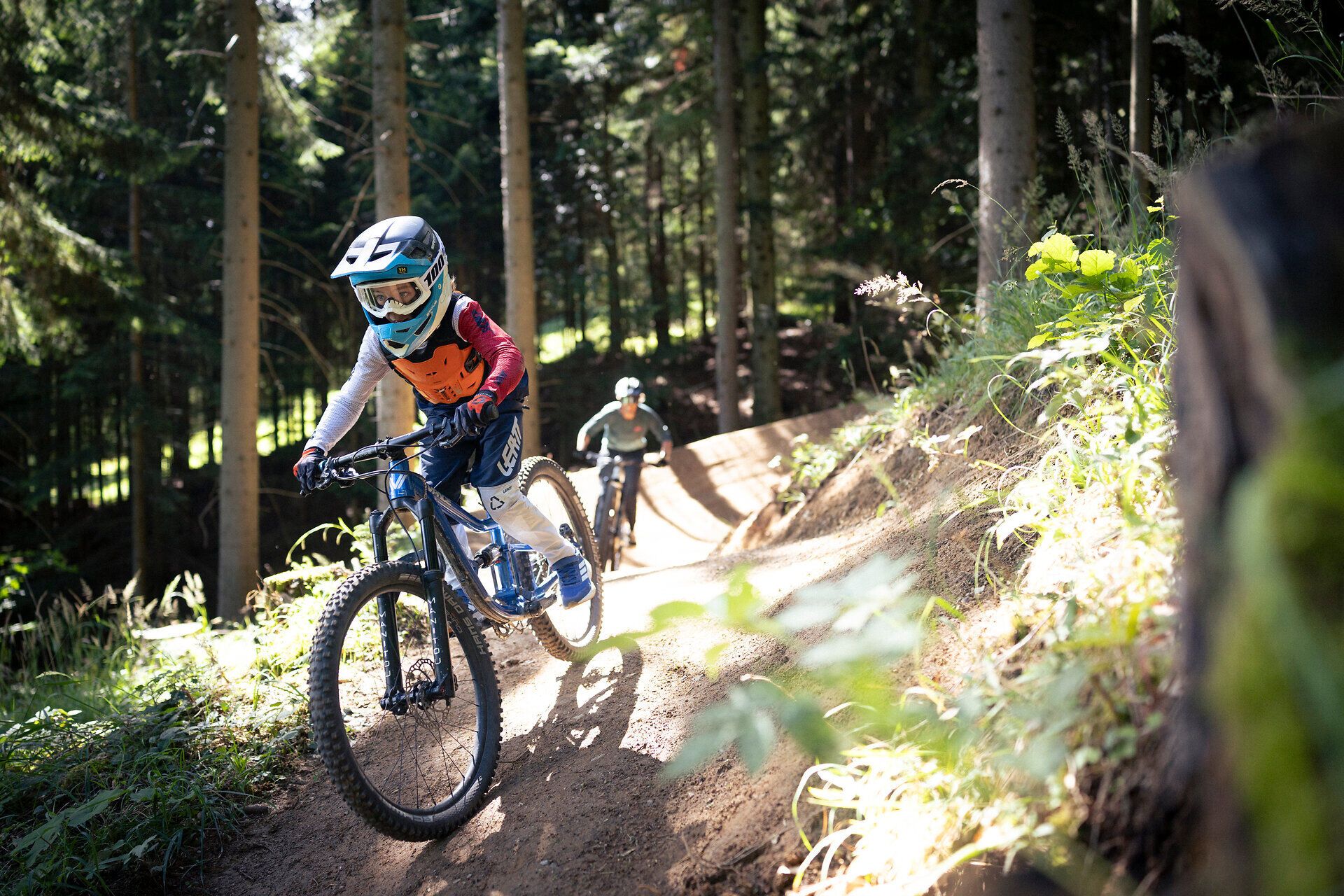 Bike-Abenteuer am Schneeberg: Kind beim Mountainbiken auf einem Wald-Trail im Alpenbikepark