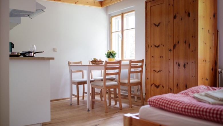 Cozy vacation apartment with wooden furniture, dining table and bed.