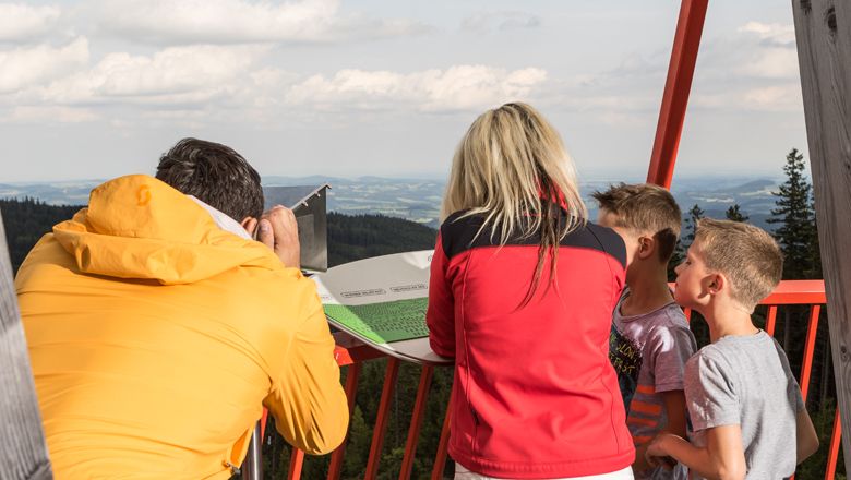 Menschen auf einem Aussichtspunkt in Mönichkirchen mit Blick auf die Landschaft.