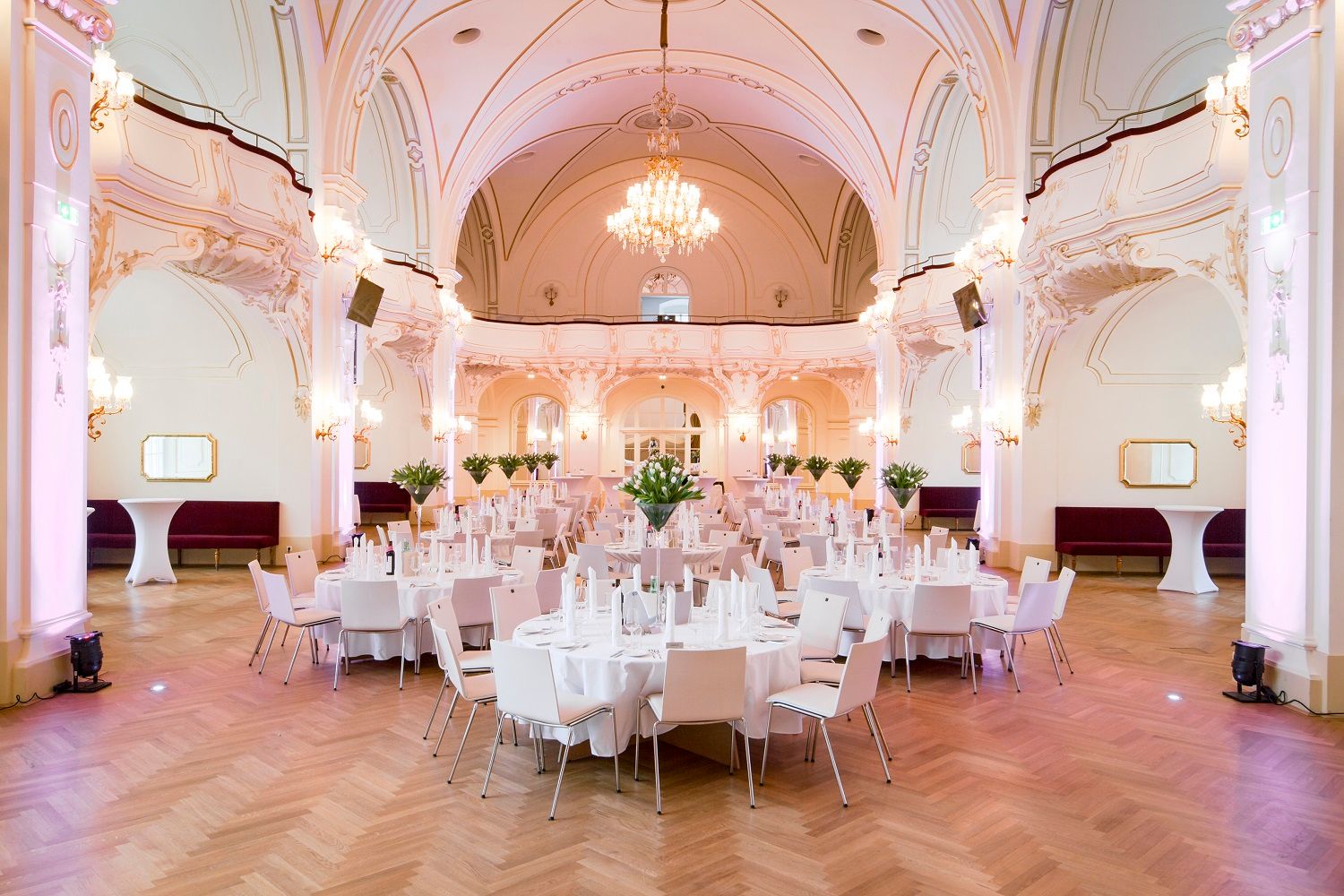 Eleganter Saal mit gedeckten Tischen und Kronleuchter.