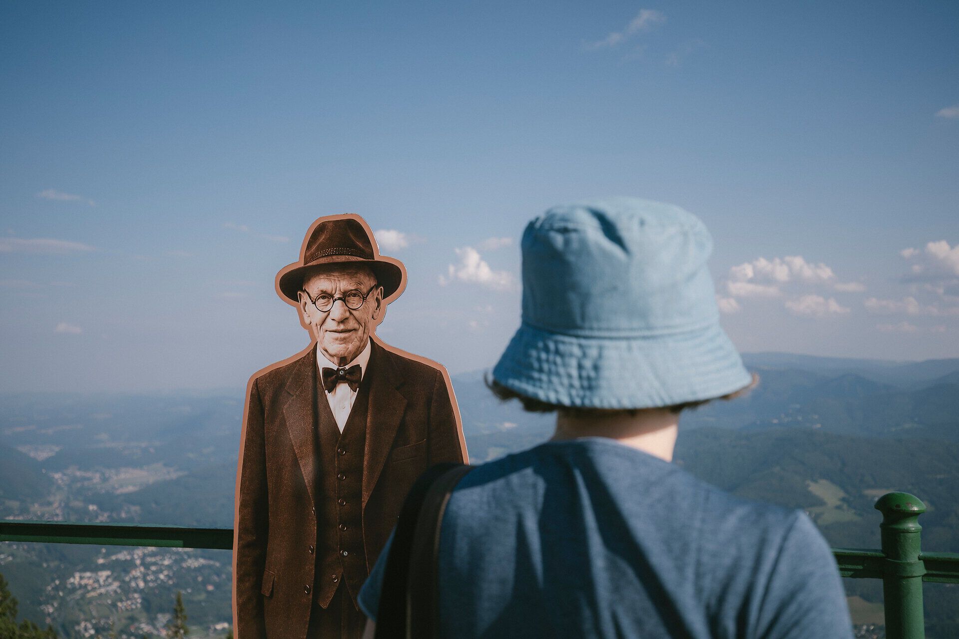 Kind betrachtet historische Figur als Aufsteller vor Bergpanorama beim Raxalm-Berggasthof