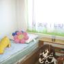 Children's room with bed, cuddly toys and toy horse.