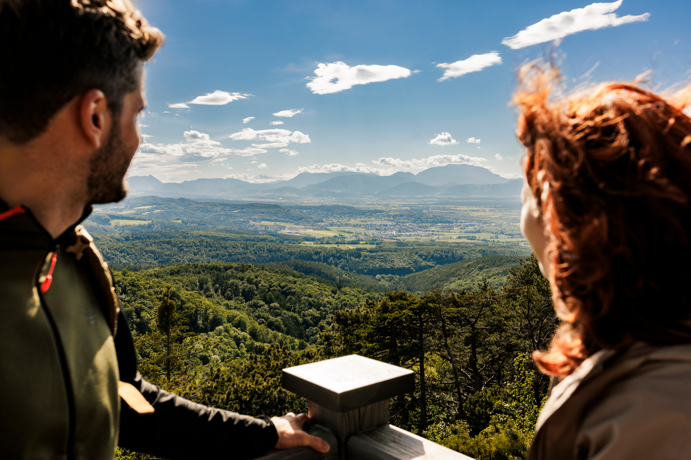 Pärchen auf Aussichtswarte mit Blick über die Berge