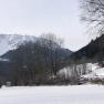 Snow-covered landscape with mountains and trees in winter.