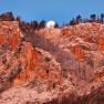 Felswand im Morgenlicht mit Vollmond am Himmel.