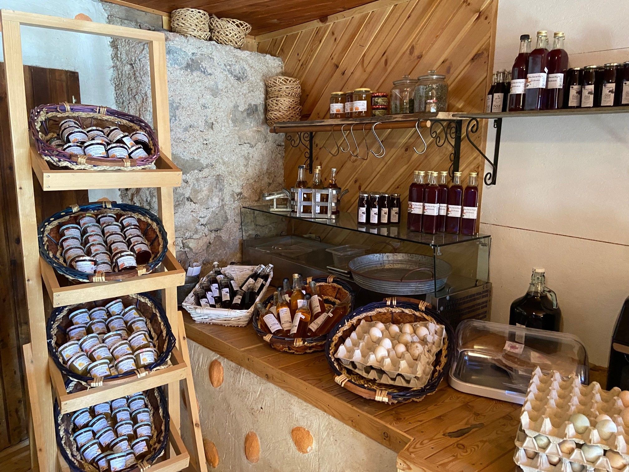 Regal mit Marmeladen, Flaschen und Eiern in einem Hofladen.