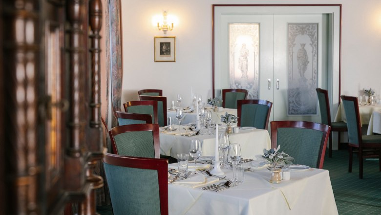 Elegantes Hotelrestaurant mit gedeckten Tischen und dekorativen Elementen.
