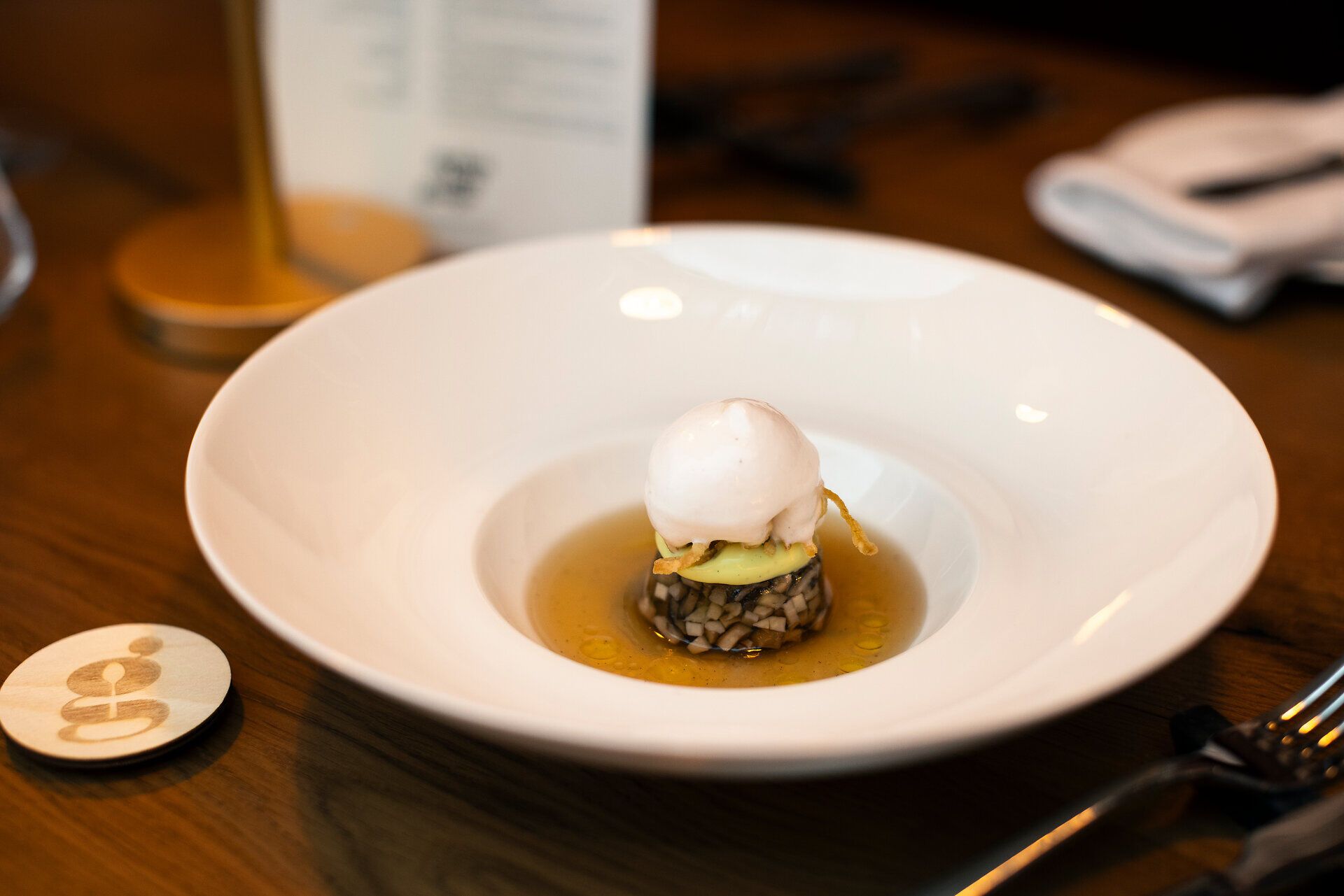 Fein angerichtetes Gericht auf einem weißen Teller in Nahaufnahme.