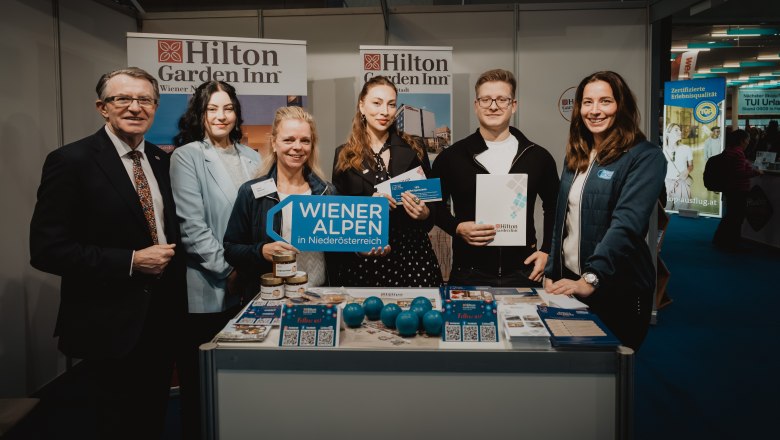 6 Personen bei einem Prospektpult von Hilton Garden Inn 