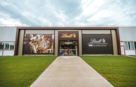 Eingang des Lindt Factory Outlet mit großen Werbebannern.
