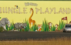 Wandbild mit Dschungeltieren und Schriftzug 'Jungle Playland'.