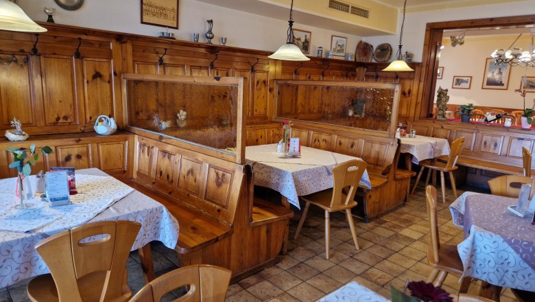 Gemütliches Gastzimmer mit Holzmöbeln und dekorierten Tischen.