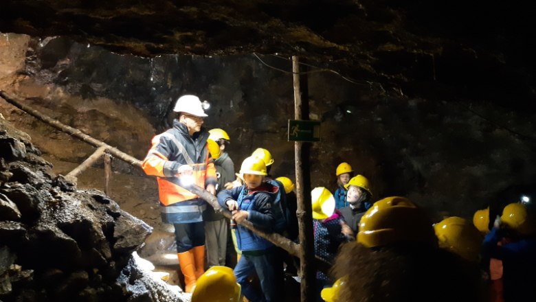 Gruppe von Menschen mit Helmen in einem Schaubergwerk.