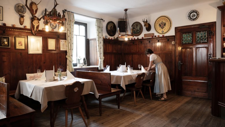 Traditionelles Wirtshaus mit Holzvertäfelung und Jagdtrophäen an den Wänden.