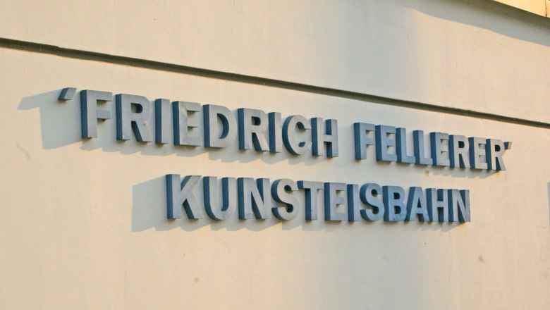 Schriftzug 'Friedrich Fellerer Kunsteisbahn' an einer Wand.