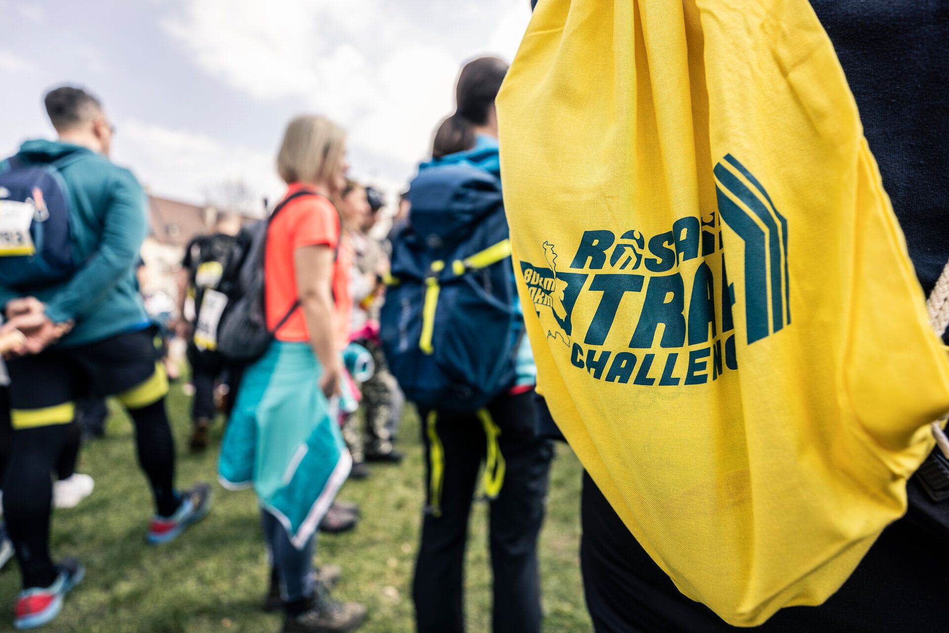 Ein Teilnehmer mit einem „Rosalia Trail Challenge“-Turnbeutel steht inmitten von anderen Teilnehmern.