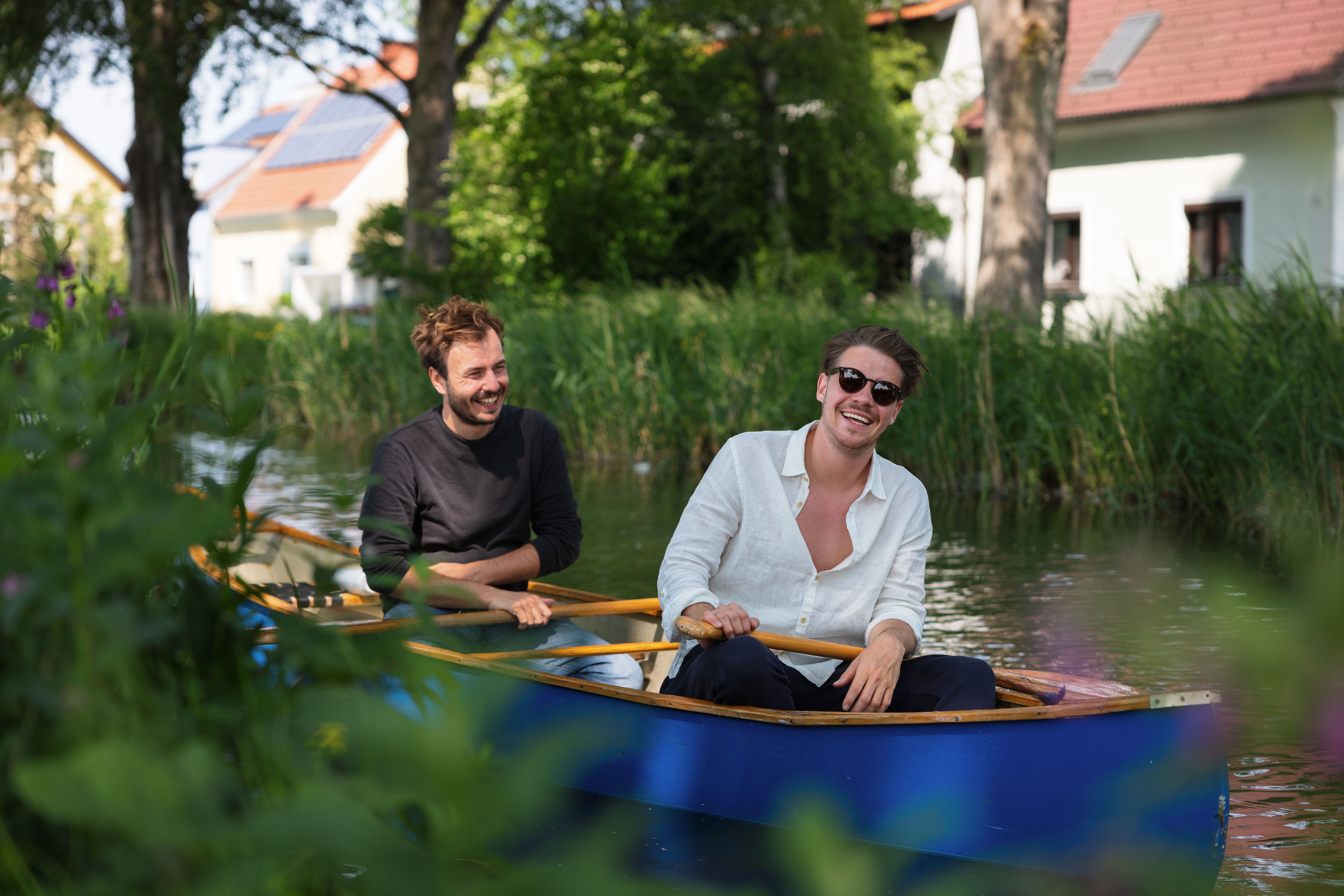zwei Männer auf einen Boot schippern über den Kanal 
