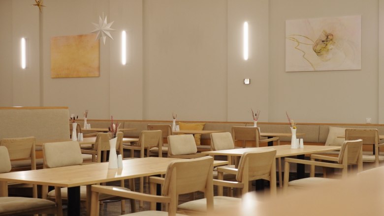 Innenansicht eines modernen Restaurants mit Holzmöbeln und minimalistischer Dekoration.