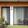 Modern terrace with two chairs and a table in front of a guest house.