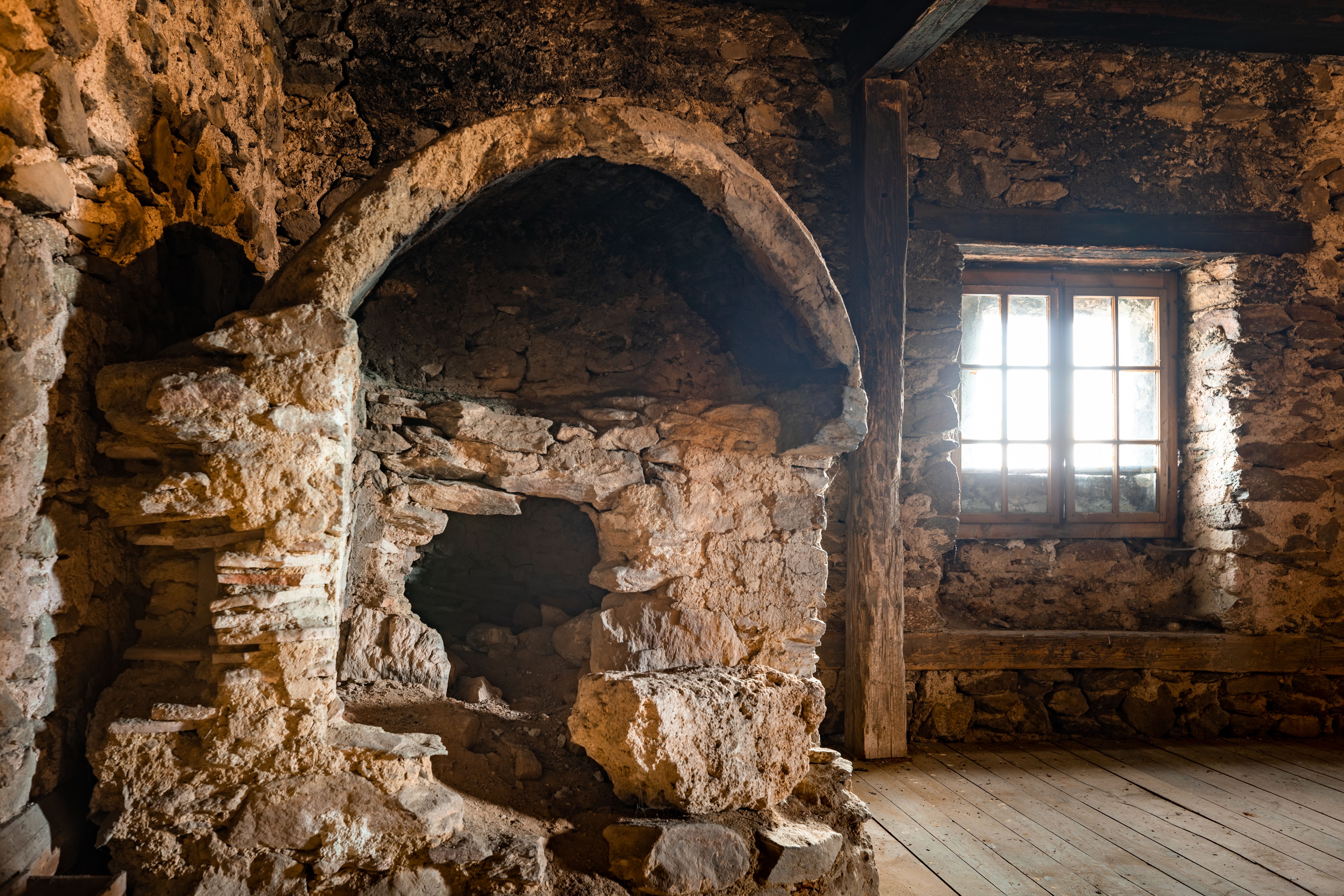 Teilweise eingestürzter Backofen aus Stein der Wehrkirche Lichtenegg. Rußablagerungen sind sichtbar, daneben ein Fenster in der Steinmauer.