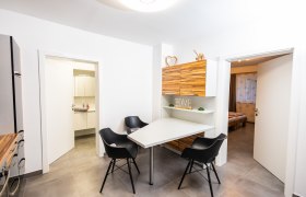 Moderner Essbereich mit Tisch, schwarzen Stühlen und Holzschränken.