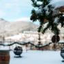 Winter terrace with fir branches and icicles in the foreground, snow-covered landscape in the background.