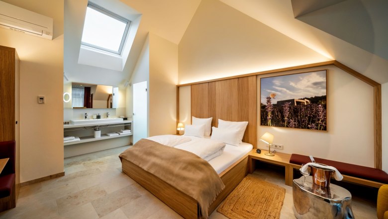 Modern hotel room with skylight, double bed and stylish furnishings.