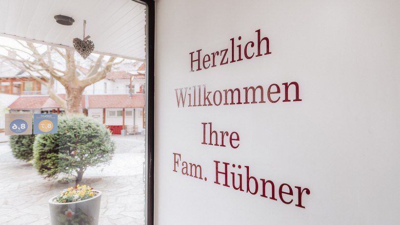 Eingangsbereich mit Begr&uuml;&szlig;ungstext an der Wand und Blick nach drau&szlig;en.