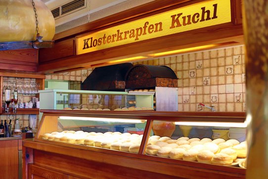 Verkaufsstand mit frischen Krapfen in einer Bäckerei.