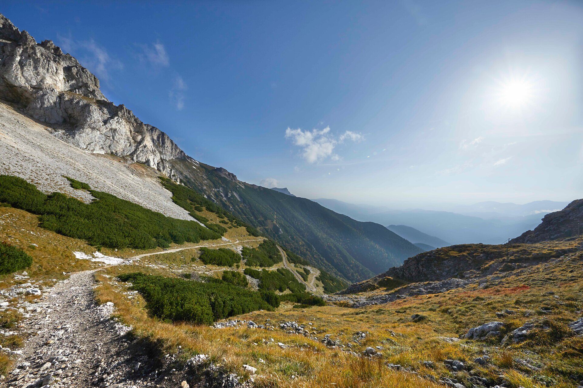 Blick über eine hochalpine Landschaft mit Wanderweg.