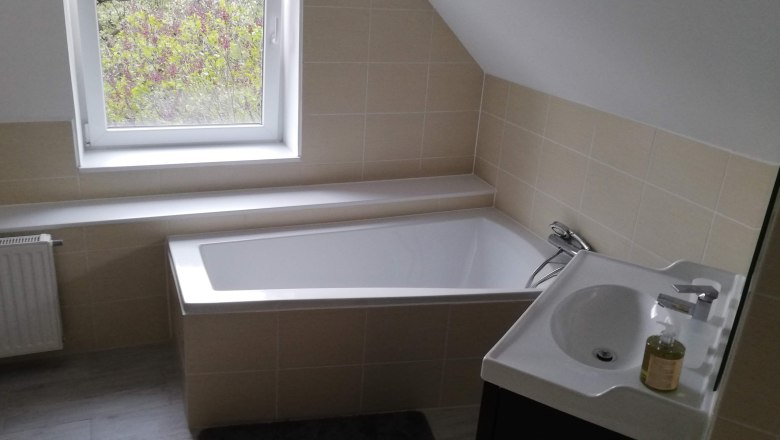 Modernes Badezimmer mit Badewanne, Waschbecken und Fenster.