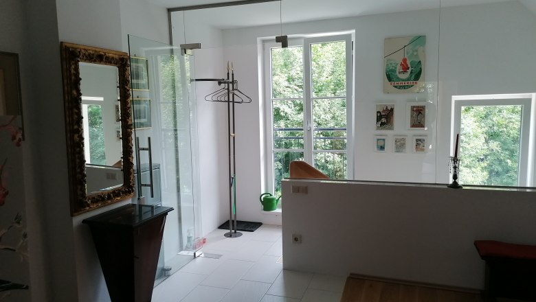 Eingangsbereich einer Ferienwohnung mit Spiegel, Kleiderst&auml;nder und Bildern an der Wand.