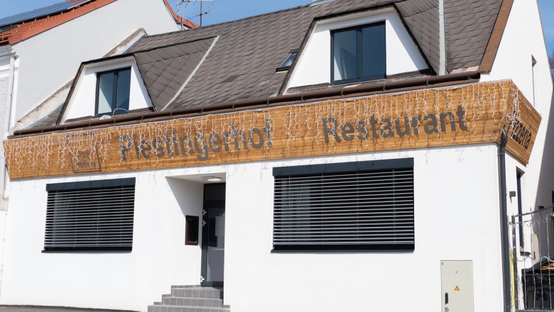 Fa&ccedil;ade of a restaurant called Piestingerhof, decorated with fairy lights.