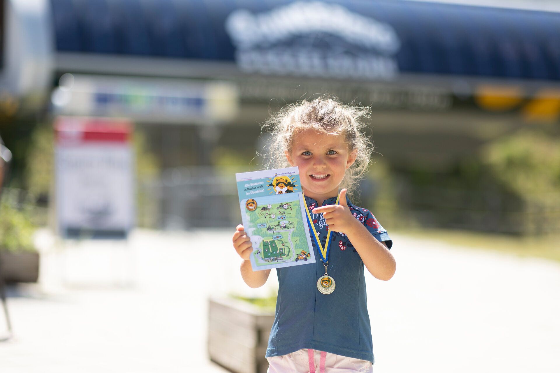 Ein strahlendes Lächeln erhellt das Gesicht eines kleinen Mädchens, das stolz eine Urkunde in der Hand hält. Umgeben von der malerischen Kulisse der Wiener Alpen, strahlt die Freude über den gelungenen Tag in der Natur. Die frische Bergluft und die unberührte Landschaft laden Familien ein, unvergessliche Abenteuer zu erleben.