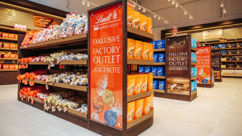 Regale mit Lindt Schokolade in einem Outlet.