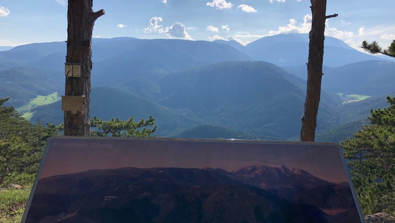 G&ouml;sing vantage point with a plaque and view of wooded mountains