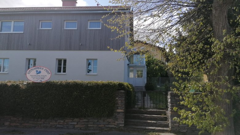 Ferienwohnung 208, © Familie Reitbauer Zweistöckiges Gebäude mit Schild 'Alpengasthaus Ewin' und Garten.