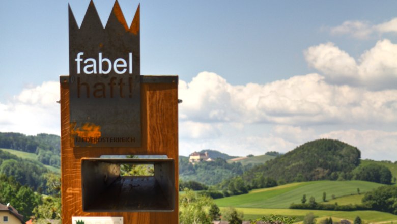 Metal sculpture with the inscription 'fabulous!' in front of a hilly landscape in Lower Austria.