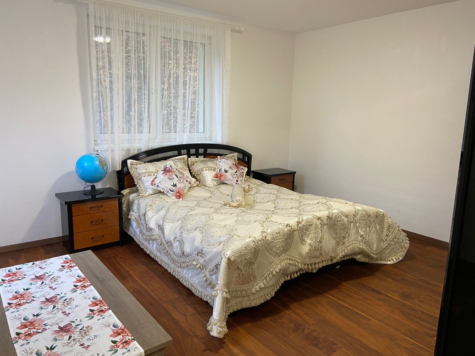 Schlafzimmer mit Doppelbett, Nachttischen und Globus.