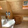 Wood-paneled bathroom with washbasin, mirror, skylight and radiator.