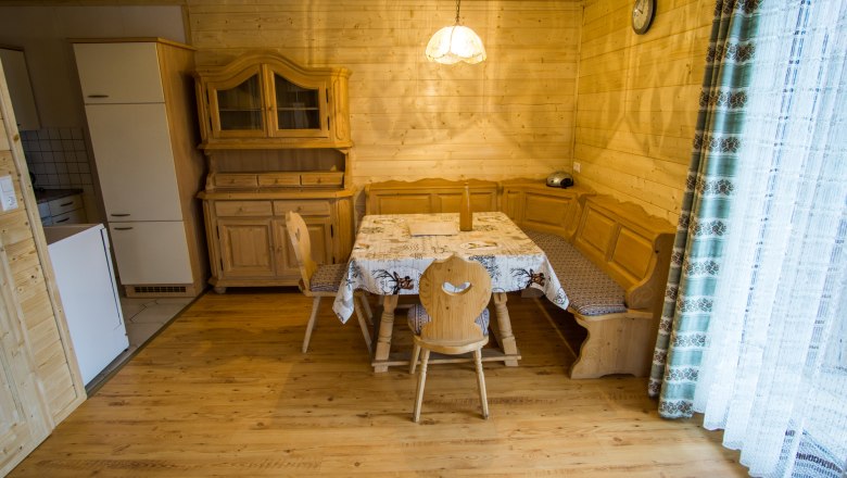 Essbereich in einem rustikalen Ferienhaus mit Holzmöbeln und Eckbank.