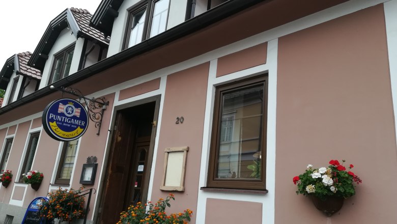 Außenansicht Bärnwirt, © Wiener Alpen Außenansicht eines Gebäudes mit Schild 'Puntigamer' und Blumendekoration.