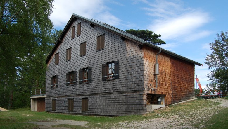 Neunkirchner Haus auf der Flatzer Wand mit Holzfassade und blauen Himmel.