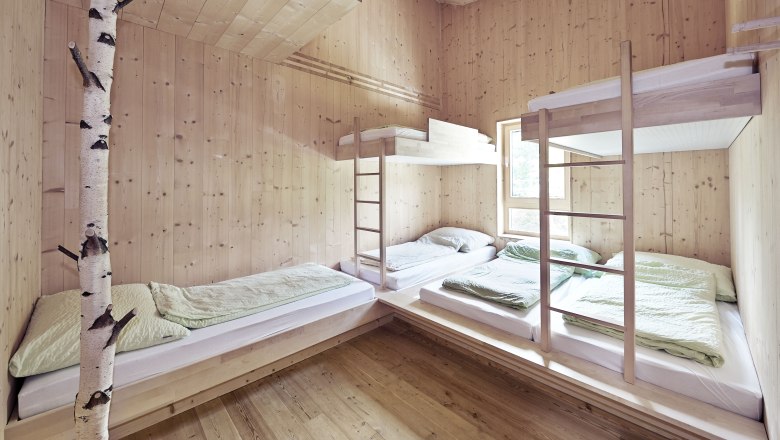 Mehrbettzimmer mit Holzverkleidung und Etagenbetten im Naturfreundehaus Knofeleben.