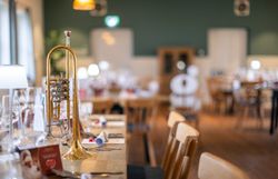 Trompete steht am fein gedeckten Tisch bei der Veranstaltung Gedanken-Gänge im s'Hutwisch