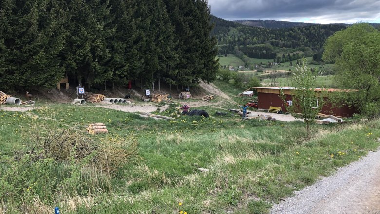 3D-Bogenparcours in einer Waldlandschaft mit Zielscheiben und einem Gebäude.