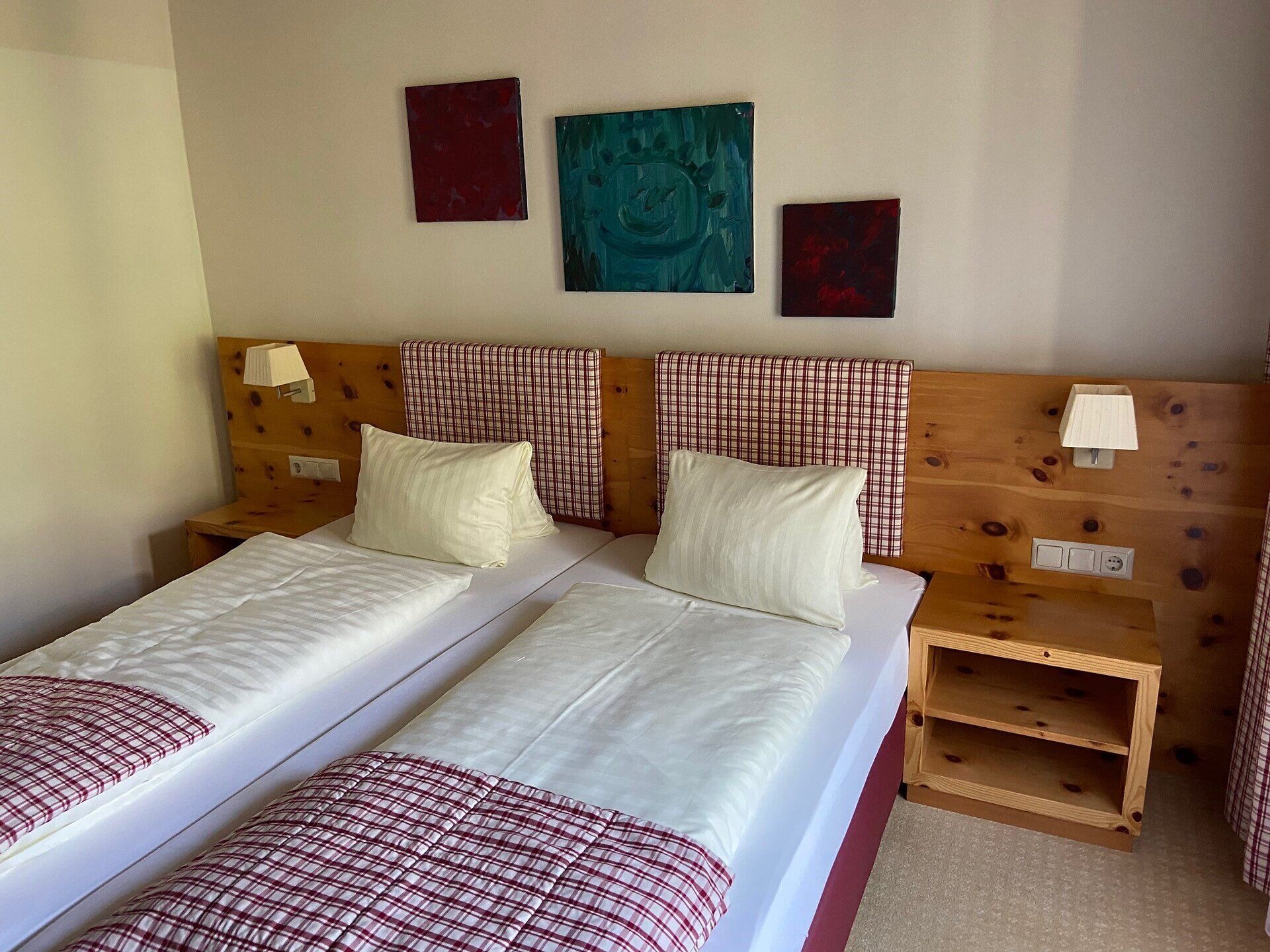 Gemütliches Doppelzimmer im Forellenhof mit Holzelementen und grüner Wandgestaltung