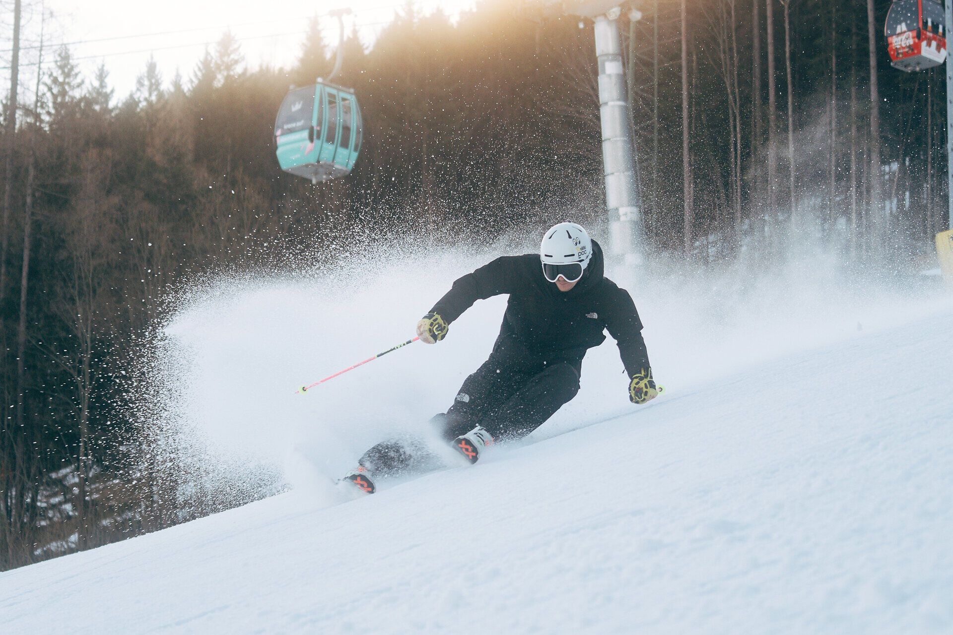 Skifahrer bei einer schwungvollen Abfahrt auf der verschneiten Piste am Semmering Hirschenkogel.