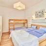 Bedroom with double bed and bunk bed, bright furnishings.